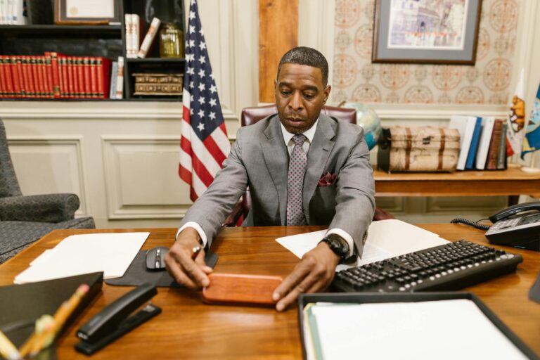 Lawyer seated at desk in office arranging documents with focus and professionalism.